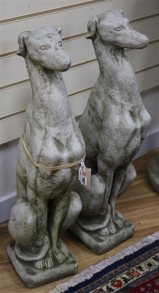 A pair of reconstituted stone model of hounds sejant H.74cm